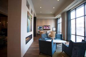 uma sala de estar com cadeiras, uma mesa e janelas em Hampton Inn & Suites St. Paul Downtown em Saint Paul
