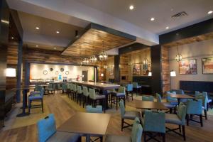 a restaurant with tables and chairs and a bar at Hampton Inn & Suites St. Paul Downtown in Saint Paul