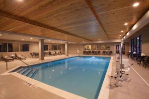 a large swimming pool in a hotel with tables and chairs at Hampton Inn & Suites St. Paul Downtown in Saint Paul