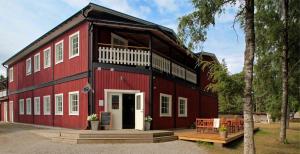 a red barn with a porch and a table at Hotel Dalhem in Dalhem