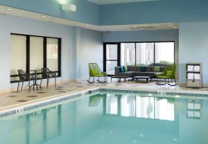 a swimming pool with chairs and a couch at Hampton Inn Bentonville-Rogers in Rogers