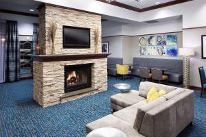 a living room with a fireplace and a tv at Hampton Inn & Suites Oklahoma City-Bricktown in Oklahoma City