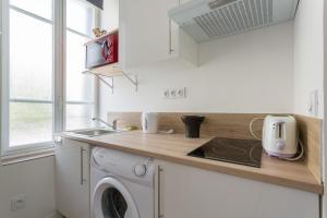 a kitchen with a sink and a washing machine at Le George Gouy-Joli studio- Debourg Gerland in Lyon