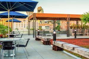 a patio with tables and chairs and blue umbrellas at Hampton Inn And Suites By Hilton Portland-Pearl District in Portland