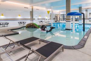 波特蘭的住宿－波特蘭珍珠區希爾頓漢普頓套房酒店，一个带椅子和桌子的大型游泳池