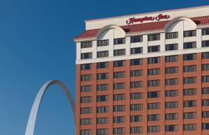 ein Hotel mit Torbogen im Hintergrund in der Unterkunft Hampton Inn St Louis- at the Arch in Saint Louis