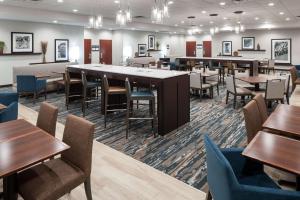 Hampton Inn St Louis- at the Arch في سانت لويس: غرفة طعام مع طاولات وكراسي وطاولة