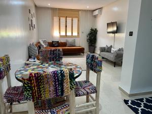 ein Wohnzimmer mit einem Tisch und Stühlen in der Unterkunft chez joudia et mamoun in Marrakesch