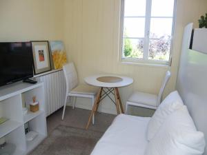 una pequeña sala de estar con mesa y TV. en CASA MARGARITAS, en Ourense