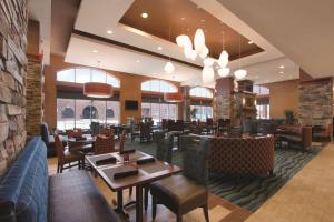 a restaurant with tables and chairs and windows at Hilton Garden Inn Oklahoma City/Bricktown in Oklahoma City