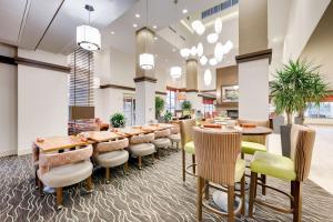een grote eetkamer met tafels en stoelen bij Hilton Garden Inn North Houston Spring in Spring