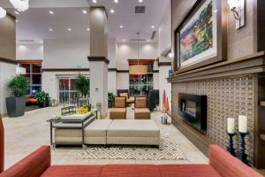 - un hall avec un canapé et une cheminée dans l'établissement Hilton Garden Inn North Houston Spring, à Spring