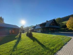 a shadow of a house on a green lawn at Ubytování Polanský Dvůr in Velké Karlovice