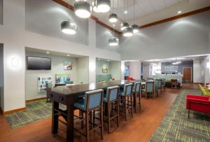 a waiting room with a long table and chairs at Hampton Inn & Suites St. Louis at Forest Park in Saint Louis
