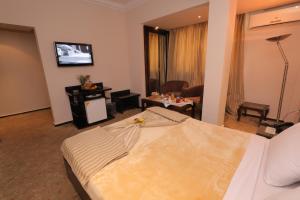 een hotelkamer met een bed en een woonkamer bij Swiss Inn Hotel Mohandeseen in Caïro