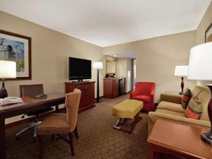 a hotel room with a desk and a living room at Embassy Suites by Hilton Austin Arboretum in Austin