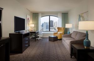 a living room with a couch and a tv in a hotel room at Hilton Garden Inn Austin Downtown-Convention Center in Austin