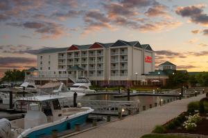 a large hotel with boats docked in a marina at Hilton Garden Inn Kent Island in Grasonville