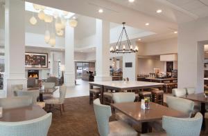 a restaurant with tables and chairs and a bar at Hilton Garden Inn Kent Island in Grasonville