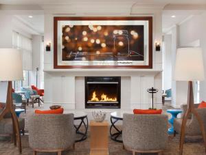 a living room with a fireplace and a tv at Hilton Garden Inn Kent Island in Grasonville