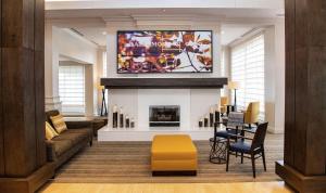 a living room with a tv above a fireplace at Hilton Garden Inn BWI Airport in Linthicum Heights