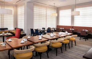 a dining room with wooden tables and chairs at Hilton Garden Inn BWI Airport in Linthicum Heights