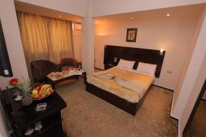 um quarto de hotel com uma cama e uma sala de estar em Swiss Inn Hotel Mohandeseen no Cairo