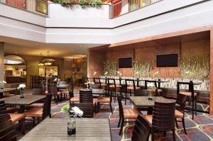 a restaurant with tables and chairs and a bar at Embassy Suites by Hilton Dallas Near the Galleria in Dallas