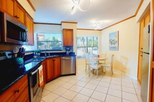 a kitchen with a table and a dining room at Paradise Sol 2Bd2Ba Condo on Golf Course Near Bch in St Petersburg