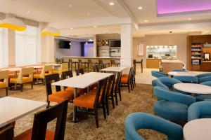 a restaurant with tables and chairs and a bar at Hilton Garden Inn Cincinnati Blue Ash in Blue Ash