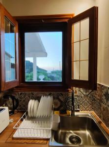 a kitchen counter with a sink and a window at Guestroom Happynest no.3 in Melíssia