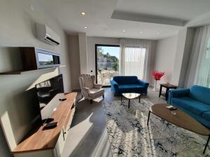 a living room with a blue couch and a tv at Dreamy luxury duplex villa with a special view and 300 meters of private garden in Alanya