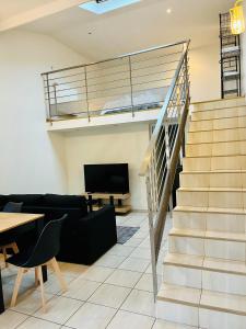 Sala de estar con escaleras que conducen a un loft en Appartement individuel situé à Créteil proche Henri Mondor, en Créteil