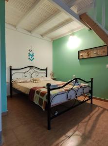 a bedroom with a bed in a room with green walls at Guestroom Happynest no.3 in Melíssia