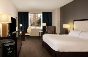 a hotel room with a bed and a desk and a television at Hilton Alexandria Old Town in Alexandria +80 photos