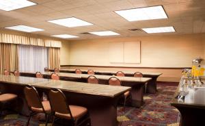 フラッグスタッフにあるEmbassy Suites by Hilton Flagstaffの大きなテーブルと椅子付きの会議室を利用できます。