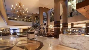 een lobby met een trap en een kroonluchter bij Hilton Fort Worth in Fort Worth