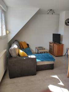 ein Wohnzimmer mit einem Bett und einem Sofa in der Unterkunft A l'Orée du Bois ''Les Hêtres'' in Guewenheim