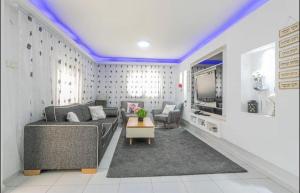 uma sala de estar com um sofá e uma televisão em Kamer guesthouse em Bersebá