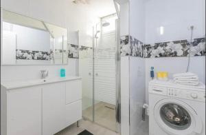 uma casa de banho branca com uma máquina de lavar roupa e um lavatório em Kamer guesthouse em Bersebá