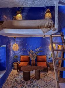 a room with two bunk beds and a table and chairs at Casa Amina in Chefchaouene