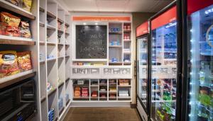 a grocery store aisle with a refrigerator and lots of food at Hampton Inn & Suites N Ft Worth-Alliance Airport in Roanoke