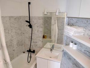 La salle de bains est pourvue d'une douche, d'un lavabo et d'une baignoire. dans l'établissement Appartement vintage, à Vitry-sur-Seine