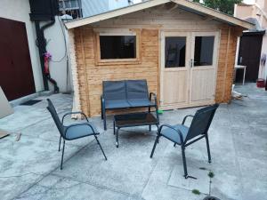 a group of chairs and a bench in front of a shed at Appartement vintage in Vitry-sur-Seine