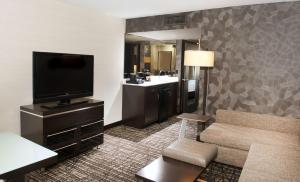 a hotel room with a television and a couch at Embassy Suites by Hilton Las Vegas in Las Vegas