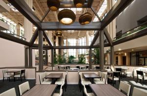 un restaurant avec des tables et des chaises en bois ainsi que des fenêtres dans l'établissement Embassy Suites by Hilton Palm Beach Gardens PGA Boulevard, à Palm Beach Gardens