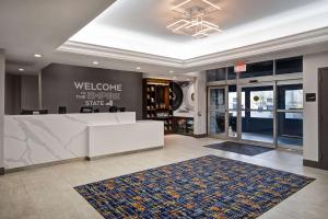 a lobby with a white reception desk and a rug at Hampton Inn NY-JFK in Queens