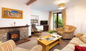 a living room with a couch and a fireplace at Old Barn Cottage in Newby Bridge