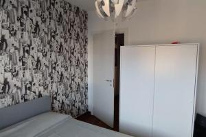 a bedroom with a bed and a wall with a wallpaper at Appartamento di Anna in La Spezia