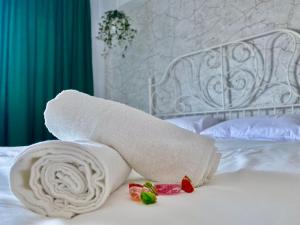 a rolled up towel on a bed with candy at Union Experience - City Center in Timişoara
